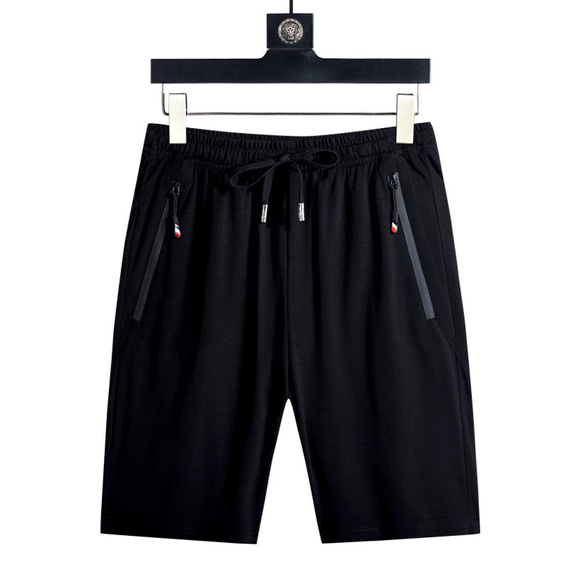 Black shorts on a hanger against a white background
