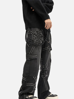 Person wearing black cargo pants with unique designs on a white background