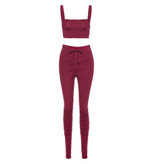 Maroon two-piece outfit with a crop top and high-waisted pants on a white background