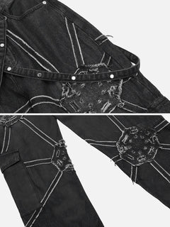 Close-up of black denim jeans with decorative stitching and a belt.