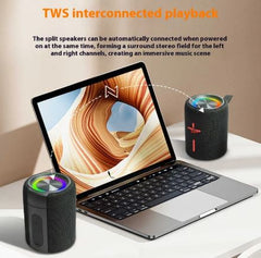 Laptop with two wireless speakers on a desk, showcasing TWS interconnected playback feature.