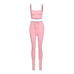 Pink two-piece outfit with a crop top and leggings on a white background
